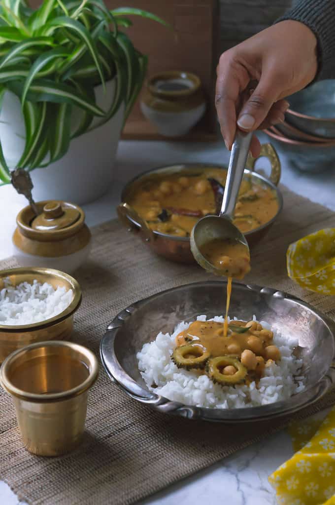 Paavakai Pitla displayed with a hand model pouring on a plate with white steamed rice