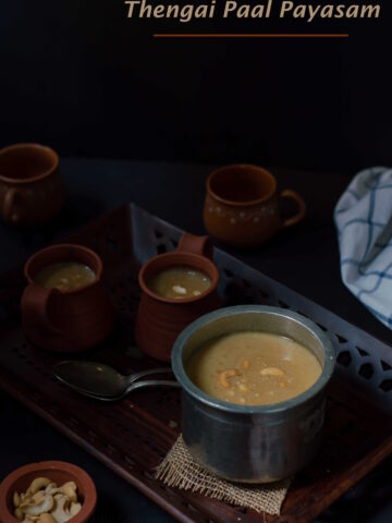 Thengai Paal Payasam displayed in tall vessel in a dark moody background.